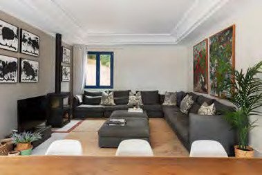 Living room at Villa Lentisco with a wood-burning stove and dark sectional sofa