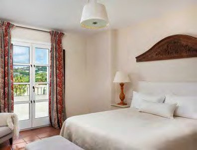 Bedroom at Cortijo Lirio de Noche with a carved wood headboard and terrace views