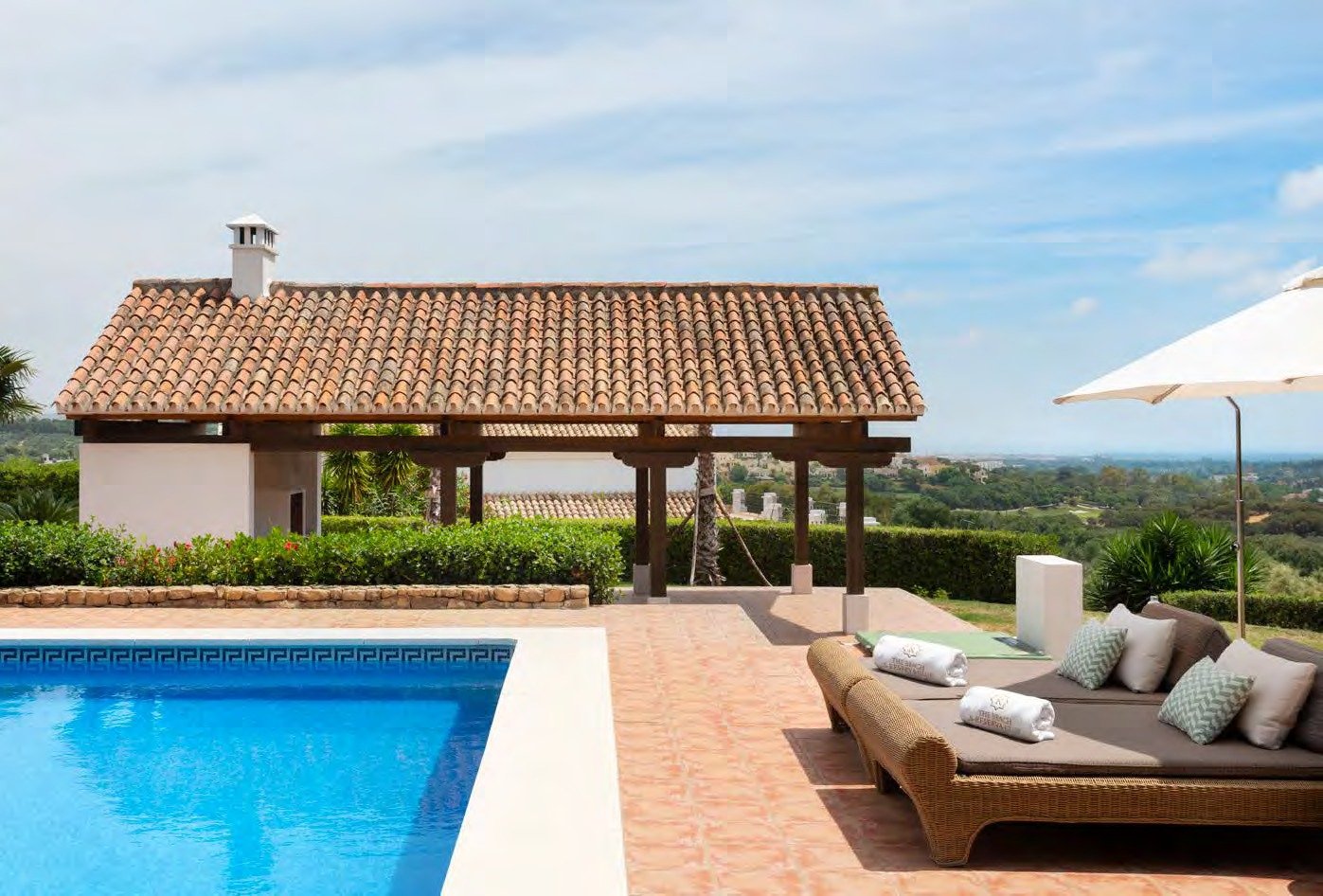 Pool terrace at Cortijo Lirio de Noche with a traditional pergola and valley views