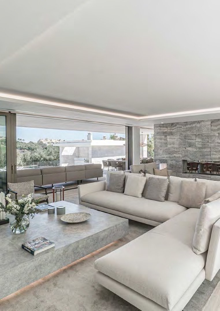 Open-plan living room at Villa La Escondida with floor-to-ceiling glass and hillside views