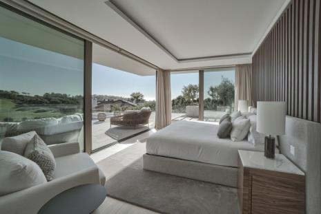 Bedroom at Villa La Escondida with floor-to-ceiling glass doors onto the golf course